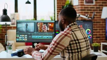 African american filmmaker man works on a professional shoot, managing the editing timeline of a project. Employing modern editing tools and color grading software. Camera B. video