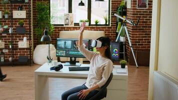 Asian modern editor using virtual reality glasses and mixing clips, using interactive gadget vr headset to edit and do color grading for a montage. editing software. Camera A. video