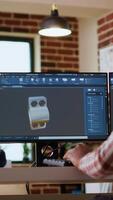 Vertical African american industrial designer works on prototypes in a creative studio. Doing tech driven remote work with 3D modeling and CAD software, industrial tools for technical precision. Camera B. video