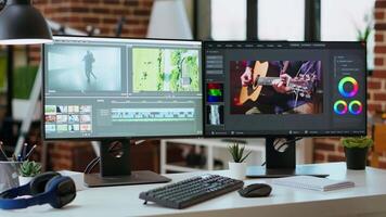 Empty modern office workspace with dual monitors displaying a editing timeline and color grading tools. Perfect for filmmakers and media creators working remotely on projects. video