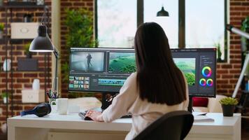 Asian woman uses advanced editing software in a modern office. Working on dual monitors for media creation and the cinematic production process, creative studio. Camera B. video