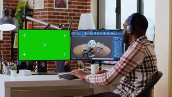 Software developer creates a gear prototype on dual monitors next to chroma key display, home office remote work. Expert does 3D modeling for innovation in the industrial design industry. Camera B. video