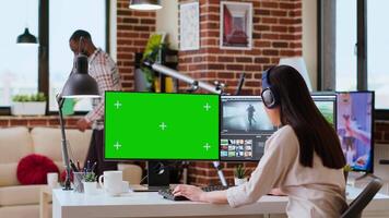 Asian woman working from home as a freelance editor, using isolated mockup display and mixing software. Creative workspace equipped with dual monitors and tech tools. Camera B. video