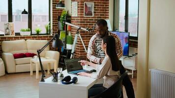 Interracial creative team programing code on a laptop and debugging, using digital tools at home. Professional coders team working on software development and internet security. Camera A. video