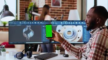 African american industrial designer works on 3D renders and isolated mockup, using digital tools and dual monitors. Engineer driven by creativity and technical expertise in design. Camera B. video