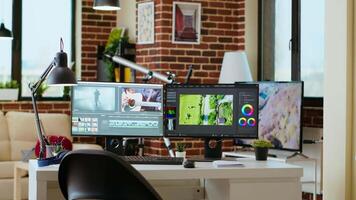 Clean modern desk setup in a living room designed for media production, post production. Dual monitors display editing software, tech tools and a color wheel add a professional touch. video