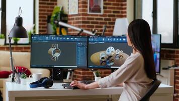 Professional industrial designer working with CAD software on dual monitors, creating 3D prototypes for a tech driven environment. 3D modeling software for innovative design. Camera B. video