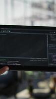 Vertical Software engineer using tablet to design algorithms that enable machines to learn from data. Close up of admin in office training and deploying large scale deep learning models with device, camera B video