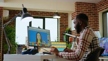 Male african american designer works with photo editing software in his creative workspace at home. Using dual monitors to ensure productivity and innovation in the graphic design world. Camera A. video
