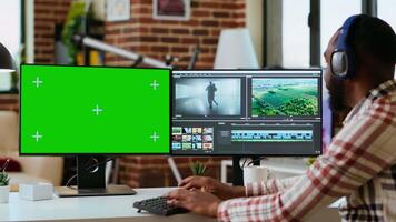 Male filmmaker editing a project in a modern color grading software, using copy space screen. Young man employee works on dual monitors during creative process of production. Camera B. video