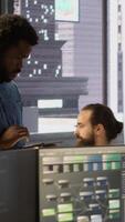 Vertical Computer scientist resuming work after strolling in workspace, doing software debugging using PC. Man walking with tablet in office, fixing coding issues using computer, camera A video