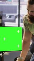 Vertical Developer using mockup PC, being assisted by colleague to fix applications issues, dealing with databases and server configuration. Team of IT workers using green screen computer, camera A video
