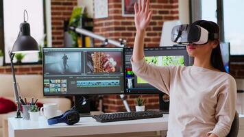 Asian modern editor using virtual reality glasses and mixing clips, using interactive gadget vr headset to edit and do color grading for a montage. editing software. Camera B. video