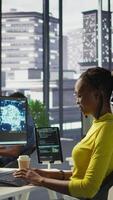 Vertical Software engineer conducts code review to fix bugs, identifying technical issues with artificial intelligence company software. African american woman debugging and optimizing code using AI, camera B video