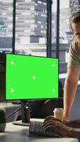 Vertical Admin doing software debugging on green screen PC, asking for help from coworker, checking errors in code. Worker fixing coding mistakes on mockup computer, being assisted by colleague, camera B video