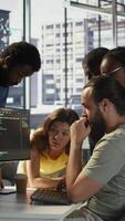 Vertical Programmers gathered together to conduct code review to fix errors, identifying technical issues with company software. Team of developers doing brainstorming, optimizing code, camera B video