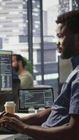 Vertical System administrator at work creating machine learning models that can process and analyze data. Close up of african american IT expert programming in office using PC, camera B video