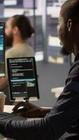 Vertical Admin creating AI machine learning models that can process and analyze data to improve decision making processes, looking at PC. Man programming in office using artificial intelligence tech, camera A video