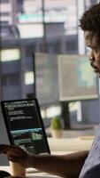 Vertical Manager coming to check on progress done by programmer creating AI machine learning models that can analyze data. Team leader supervising man doing artificial intelligence programming, camera A video