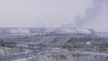 Panorama of an open quarry. Mining industry. Large quarry excavator in the background of hills of cruched stone next to a mining enterprise, panorama. Mining equipment photo
