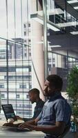 Vertical Tired admin stretches limbs while using PC for artificial intelligence computing simulating human brain. Fatigued worker relaxing back, feeling strained after working with AI neural networks, camera B video