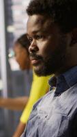 Vertical System administrator at work creating machine learning models that can process and analyze data. Close up of african american IT expert programming in office using PC, camera A video