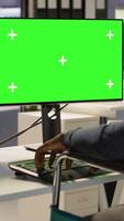 Vertical Developer with disability sitting in wheelchair fixing applications issues on green screen PC. Man with paraplegia optimizing company software with mockup computer, camera A video