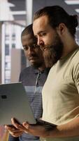 Vertical Programmer and colleague conducting experiments and tests to optimize machine learning models for performance and accuracy. IT staff members in office analyzing and interpreting complex data, camera A video