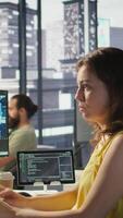 Vertical System administrator at work doing debugging of AI software using PC, checking glitches in lines of code. IT specialist in office fixing artificial intelligence coding issues using computer, camera B video