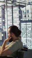 Vertical Person with impairment processing and analyzing data to automate decision making processes. IT specialist with disability programming in office, sitting in wheelchair, camera B video