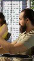 Vertical Person with impairment processing and analyzing data to automate decision making processes. IT specialist with disability programming in office, sitting in wheelchair, camera A video