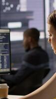 Vertical IT employee coding in programming languages to construct algorithms and build applications. Software technician developing and maintaining databases and data structures in office, camera A video