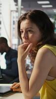Vertical Woman in office using laptop to steal company secrets after being hired by competitor, hiding from manager. Sneaky employee closing notebook lid to hide while ilegally downloading data, camera B video