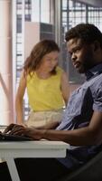 Vertical African american man designing, developing and maintaining software applications using various programming languages. System administrator debugging company servers, preventing failures, camera A video