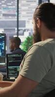 Vertical Software technician using computer for artificial intelligence computing simulating human brain. Close up of employee working with AI deep neural networks on desktop PC, camera B video