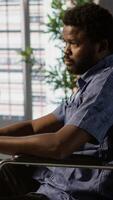 Vertical Software technician with disability in inclusive workplace working with machine learning tech. African american IT expert with paraplegia in wheelchair transforms data into predictive models video