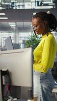 Vertical Computer scientist working, doing software debugging using notebook, troubleshooting errors. Woman standing in office, fixing coding issues using laptop, solving tasks, camera B video