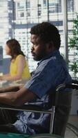 Vertical Software technician with disability in inclusive workplace working with machine learning tech. African american IT expert with paraplegia in wheelchair transforms data into predictive models video