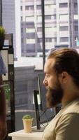 Vertical Machine learning infrastructure technicians using tablet to do checkup on algorithms that enable machines to learn from data. Coworkers in office training deep learning models using device video