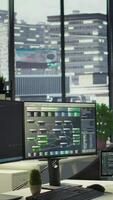 Vertical Empty IT department office used for building artificial intelligence machine learning software technology. Panning shot of bright modern company workspace with nobody in and devices left open on desks video
