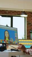 Vertical Male african american designer works with photo editing software in his creative workspace at home. Using dual monitors to ensure productivity and innovation in the graphic design world. Camera A. video