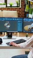 Vertical Professional industrial designer working with CAD software on dual monitors, creating 3D prototypes for a tech driven environment. 3D modeling software for innovative design. Camera A. video