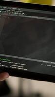 Vertical Software engineer using tablet to design algorithms that enable machines to learn from data. Close up of admin in office training and deploying large scale deep learning models with device, camera A video
