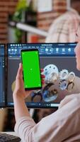 Vertical Asian freelancer developer working with headphones and chroma key screen, creating a new prototype for manufacturing industry. Female 3D modeling engineer at her home office. Camera B. video