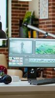 Vertical Modern digital workspace in the living room focused on tech and productivity, dual monitors displaying post production tools for creation. Clean desk setup supports efficient production. video
