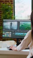 Vertical Female filmmaker working on post production from home office, editing timelines and color grading for a shoot. Tech driven workspace showcases a digital workflow for production. Camera B. video
