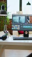 Vertical Empty office desk with a editing software running on computer, production and mixing to edit footage. Professional program for filmmaking media, creative studio. video