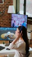 Vertical Asian professional engineer works on coding industrial designs using advanced software tools. Living room office includes dual monitors and technical equipment for high productivity. Camera A. video