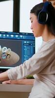 Vertical Asian professional engineer works on coding industrial designs using advanced software tools. Living room office includes dual monitors and technical equipment for high productivity. Camera B. video