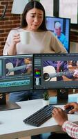 Vertical Creative team interracial partners collaborating on a editing project, using high end production software for color grading and mixing. Diverse couple uniting forces for work. Camera A. video